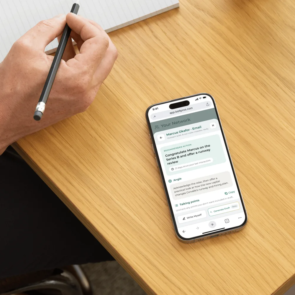 BD4 app on a phone resting on a desk beside a notebook
